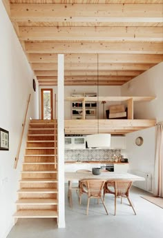 an open floor plan with stairs leading up to the kitchen and dining room area in this modern home