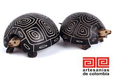 two small tortoises with designs on them sitting next to each other in front of a white background