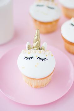 cupcakes with white frosting and pink icing decorated with gold unicorn ears