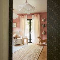 a living room with pink walls and white furniture