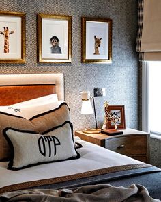 a bedroom with giraffes and pictures on the wall above the headboard