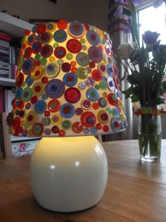 a lamp that is sitting on top of a table next to a vase with flowers in it