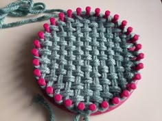 a close up of a crocheted bag with pink and blue beads on it