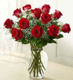 a vase filled with red roses on top of a table