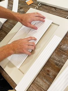 a man is working on an unfinished piece of paper that he has made from cardboard