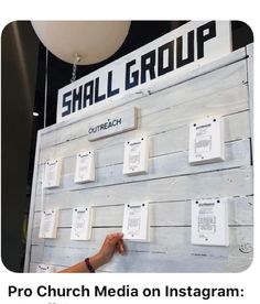 a person pointing to a sign with several small pieces of paper on it that says shal group