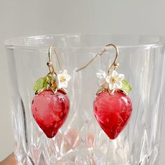 ♥ This exquisite earring features a stunning crystal texture that radiates beautiful light, adding a shimmering effect. The vibrant red strawberry design complements the delicate, translucent leaves, creating a captivating charm. The intricate details and glossy surface enhance the allure of these earrings. They are adored by garden enthusiasts and cherished by lovely young girls Length: 1.3 inches total (3.4cm) ♥ Care instructions: Substances like oil, nail polish, nail polish remover, chlorine, and perfume may react with metal/plated jewelry and cause it to tarnish.  This is also true for sweat, so make sure you remove your jewelry when you exercise or doing anything requiring heavy work and when swimming.  Each pair of earrings is carefully handcrafted to ensure that every detail is per Cute Red Flower Jewelry, Cute Red Earrings With Fruit Design, Sweet Red Earrings For Gift, Cute Red Strawberry Print Earrings, Red Fruit Design Dangle Jewelry, Red Fruit Design Drop Earrings, Red Dangle Jewelry With Fruit Design, Sweet Red Jewelry For Valentine's Day, Cute Red Resin Jewelry