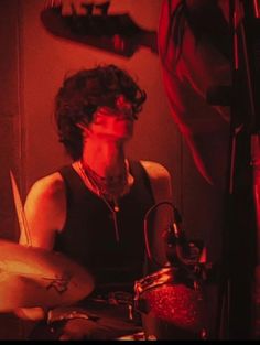 a man sitting in front of a drum set