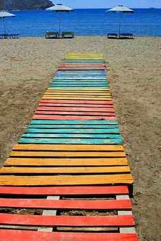 colorful wooden planks are lined up on the beach