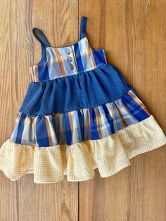 a blue and yellow dress sitting on top of a wooden floor