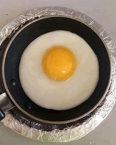 an egg frying in a pan on top of a stove