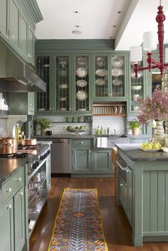 a kitchen filled with lots of green cabinets and counter top space next to a wooden floor