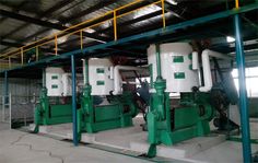 two large white tanks sitting inside of a building next to other machines and machinery in the background