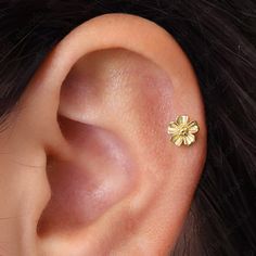 a close up of a person's ear with a small flower on the side