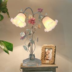 a lamp that is sitting on top of a table next to a potted plant