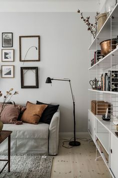 a living room filled with furniture and lots of pictures on the wall above it's bookshelf