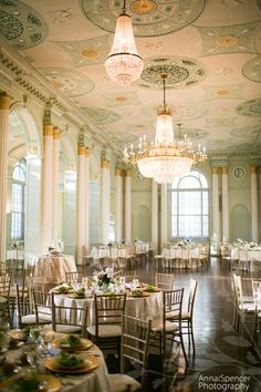 an elegant ballroom with chandeliers and tables