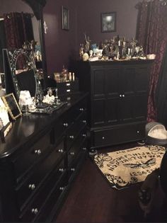 a room with a dresser, mirror and other items on the table in front of it