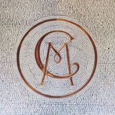 the logo for an art museum is shown in this mosaic tile wall with gold and black letters