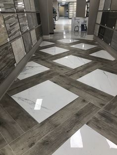 an empty hallway with white and grey tiles on the floor is pictured in this image