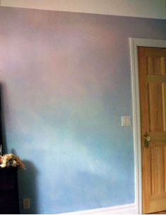 an empty room with blue walls and a television mounted on the wall in front of it