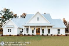 a large white house with lots of windows on the front and side of it's roof