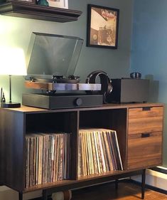 a record player sitting on top of a wooden cabinet