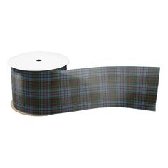 a roll of black watch tartan ribbon on a white background with a brown and blue plaid pattern