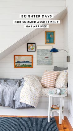 an attic bedroom with white walls and blue rugs on the floor, there is a bed