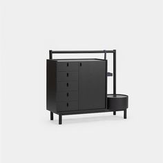 a black cabinet with three drawers and two stools next to it on a white background