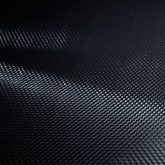 a close up view of a black textured surface with light coming from the top