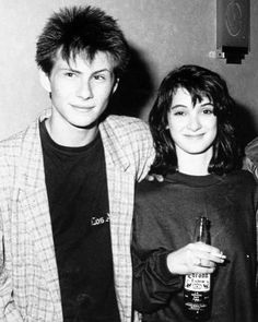 two men and a woman standing next to each other holding beer bottles in their hands