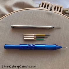 three different types of pens sitting on top of a piece of fabric