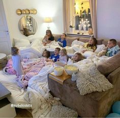 a group of children sitting on top of a couch in a living room next to each other