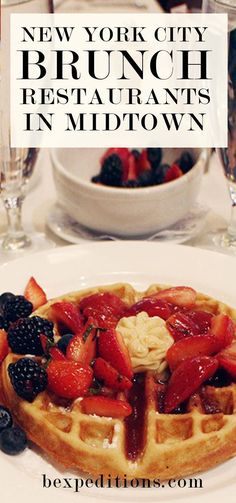 a white plate topped with waffles covered in fruit next to wine glasses and water