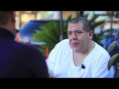 a man in white shirt talking to another man