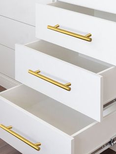 two white drawers with gold handles on them