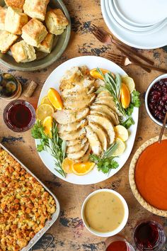 a table topped with plates of food and condiments next to bowls of sauce