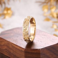 a gold ring sitting on top of a wooden stand