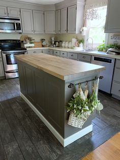 an island in the middle of a kitchen with lots of cupboards and drawers on it