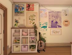 a room with many pictures and plants on the wall next to a book shelf filled with books