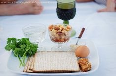 a white plate topped with crackers and vegetables next to an egg on top of a table