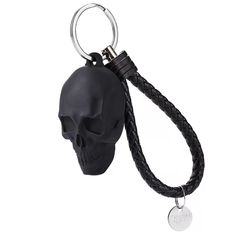 a black skull keychain with a leather cord and a metal hook attached to it