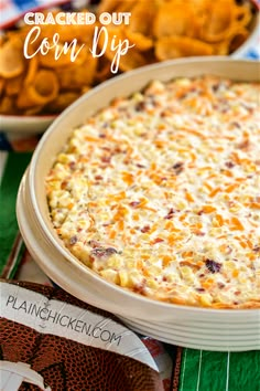 baked corn dip in a casserole dish with crackers and chips on the side