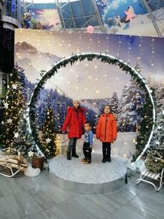 two children and an adult standing in front of a christmas display