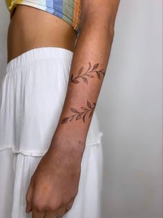 a woman's arm with a tattoo on the left side of her arm and an olive branch on the right hand