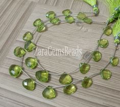 a necklace with green glass beads on a wooden surface