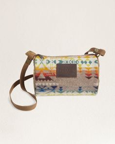 This versatile bag is made of wool jacquard and can serve as a shoulder bag, toiletry kit, or small accessory holder. It boasts a zip closure, an interior zip pocket, a leather logo patch, and a detachable canvas shoulder strap. Its antiqued brass hardware adds to its luxurious appeal. The pattern placement may vary. Loving the Highland Peak Design? Check out the additional matching bags. Highland Peak Travel Kit: Size: 9"W x 5 1/2"H x 5"D 47" removable strap 100% pure virgin wool; cotton lining Wool fabric woven in Pendleton's American mills. Care: Spot clean. No sales tax. Check out our Facebook Photos and Instagram to find fun and inspirational ideas for decorating any space. Western Boho Chic, Accessory Holder, Peak Design, Accessories Holder, Antique Brass Hardware, Toiletry Kit, Travel Kit, Western Boho, Travel Kits