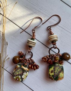 Island Garden aptly describes this pair! The polymer clay cane is beautiful with tropical flowers in shades of green and copper. They are lightweight, and all the dangles give them lots of movement, They are 2-1/4 inches long, with Copper findings and ear wires. Green Bohemian Polymer Clay Earrings, Bohemian Green Polymer Clay Earrings, Bohemian Green Flower Charm Earrings, Green Hand Painted Copper Earrings, Green Polymer Clay Flower Drop Earrings, Nature-inspired Green Dangle Flower Earrings, Garden Earrings, Island Garden, Green And Copper