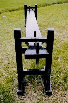 a black chair sitting on top of a lush green field